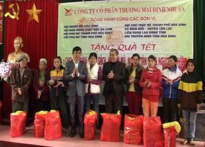 Lãnh đạo LĐLĐ tỉnh và đại diện Công ty CPTM Định Nhuận tặng quà cho hộ nghèo xã Tuân Đạo, huyện Lạc Sơn.